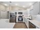 Modern kitchen featuring stainless steel appliances, white cabinets and white quartz countertops at 2055 Merideth Ter, The Villages, FL 34762