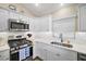 Well-equipped kitchen featuring modern appliances and white cabinets, complemented by under cabinet lighting at 2055 Merideth Ter, The Villages, FL 34762