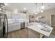Kitchen with stainless steel dishwasher, white cabinets and white quartz countertops at 2055 Merideth Ter, The Villages, FL 34762