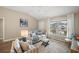 Cozy living room features large windows, a comfortable couch, and tasteful decor at 2055 Merideth Ter, The Villages, FL 34762