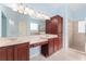 Elegant bathroom with double sinks, ample lighting, a walk-in shower, and privacy windows at 21312 Marsh View Ct, Clermont, FL 34715