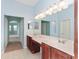 Beautiful bathroom featuring double sinks, a large mirror, and serene blue walls at 21312 Marsh View Ct, Clermont, FL 34715