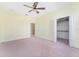 Bright bedroom featuring carpet, neutral walls, ceiling fan, and closet at 21312 Marsh View Ct, Clermont, FL 34715