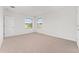 Spacious bedroom with neutral carpeting, ample natural light, and closet providing comfortable living at 21312 Marsh View Ct, Clermont, FL 34715