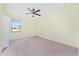 Bright bedroom with a ceiling fan, neutral carpet, and a view from the window at 21312 Marsh View Ct, Clermont, FL 34715