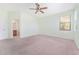 Bright bedroom featuring carpet, neutral walls, ceiling fan, and view of outdoors at 21312 Marsh View Ct, Clermont, FL 34715