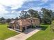 Expansive home featuring a well-manicured lawn, a two-car garage, and mature landscaping at 21312 Marsh View Ct, Clermont, FL 34715