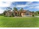 Charming single-Gathering home featuring a landscaped front yard with lush green grass and mature trees at 21312 Marsh View Ct, Clermont, FL 34715
