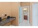 Hallway features a granite countertop, cabinets, and leads to a bathroom at 21312 Marsh View Ct, Clermont, FL 34715