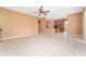 Open living room features tile flooring, a ceiling fan, and kitchen access at 21312 Marsh View Ct, Clermont, FL 34715