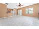 Open living room features tile flooring, a window, a ceiling fan, and a view of the kitchen at 21312 Marsh View Ct, Clermont, FL 34715