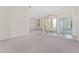 Spacious living room featuring carpet flooring, a chandelier, and arched entryways with natural light at 21312 Marsh View Ct, Clermont, FL 34715