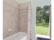 Shower tub combination with tile walls and shower curtain leading to the backyard at 21312 Marsh View Ct, Clermont, FL 34715