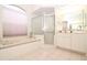 This bathroom features a shower, bathtub, and large windows creating a relaxing atmosphere at 22125 Draw Bridge Dr, Leesburg, FL 34748