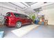A clean garage with a red minivan and overhead lighting, offering ample space for parking and storage at 22125 Draw Bridge Dr, Leesburg, FL 34748