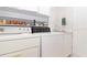 Well-equipped laundry room with washer, dryer, sink, and ample shelving for storage and organization at 22125 Draw Bridge Dr, Leesburg, FL 34748