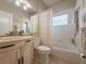 Well-lit bathroom featuring a vanity with black hardware, a mirror, and a tub with shower at 2299 Twickingham Ct, Clermont, FL 34711