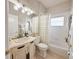 Well-lit bathroom featuring a vanity with black hardware, a mirror, and a tub with shower at 2299 Twickingham Ct, Clermont, FL 34711