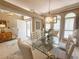 Airy dining room with glass table, chandelier, and three arched windows with shutter blinds at 2299 Twickingham Ct, Clermont, FL 34711