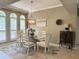 Bright dining room with stylish chandelier, glass table, and arched windows with shutter blinds at 2299 Twickingham Ct, Clermont, FL 34711