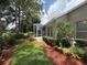 Exterior view showcasing the home, screened patio, meticulous landscaping with colorful ground cover and lawn at 2299 Twickingham Ct, Clermont, FL 34711
