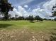 Expansive view of the well-maintained golf course with scattered trees and a bright, cloudy sky above at 2299 Twickingham Ct, Clermont, FL 34711
