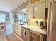 This updated kitchen features white cabinetry, stainless appliances, light countertops, and a beverage cooler at 2299 Twickingham Ct, Clermont, FL 34711