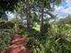 Lush, mature landscaping including colorful bromeliads lines a mulched path near the well maintained golf course at 2299 Twickingham Ct, Clermont, FL 34711