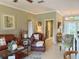 Cozy living room with leather seating, stylish decor, and a view into the dining area at 2299 Twickingham Ct, Clermont, FL 34711
