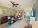 Comfortable living room featuring leather furniture, ceiling fan, and view of the kitchen and entry at 2299 Twickingham Ct, Clermont, FL 34711