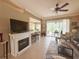 Open-concept living room with fireplace, ceiling fan, and view of kitchen and screened patio at 2299 Twickingham Ct, Clermont, FL 34711