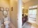 Bathroom with a toilet and double sink vanity; bedroom visible beyond at 2299 Twickingham Ct, Clermont, FL 34711