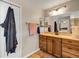 Bathroom featuring a vanity with wood cabinets, tan walls, and a view into the bedroom at 26653 Otter Creek Ln, Leesburg, FL 34748