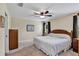 Bedroom features a ceiling fan, neutral walls, a window with dark curtains, and a closet with white doors at 26653 Otter Creek Ln, Leesburg, FL 34748