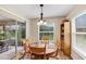 Bright dining area features a wood table with seating for four, a window view, and sliding glass door at 26653 Otter Creek Ln, Leesburg, FL 34748