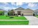 Charming single-story home featuring a manicured lawn and a two-car garage at 26653 Otter Creek Ln, Leesburg, FL 34748