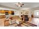 Open-concept living room and kitchen featuring wood floors, ceiling fan, and comfortable seating area at 26653 Otter Creek Ln, Leesburg, FL 34748