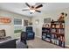 This home office has a ceiling fan, window, bookshelf and a comfy recliner at 26653 Otter Creek Ln, Leesburg, FL 34748