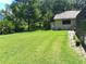 Backyard with lush green grass, mature trees, and a detached garage or shed at 29205 Old E Ml, Tavares, FL 32778