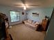 Cozy bedroom featuring light blue walls, a comfortable sofa, and natural light from the window at 29205 Old E Ml, Tavares, FL 32778