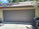 Closed two-car garage door with a dark gray finish, complemented by a matching roof and trim at 29205 Old E Ml, Tavares, FL 32778