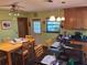 View of kitchen island, black glass cooktop, adjacent wooden dining table and chairs and back door at 29205 Old E Ml, Tavares, FL 32778