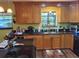 A well-lit kitchen featuring wooden cabinets, black appliances, granite countertops, and a large window at 29205 Old E Ml, Tavares, FL 32778