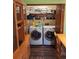 An inside laundry room with washer and dryer and wooden storage cabinet at 29205 Old E Ml, Tavares, FL 32778
