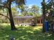 Exterior view of the screened-in pool, surrounded by lush greenery and mature trees creating a private oasis at 29205 Old E Ml, Tavares, FL 32778