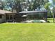 Wide view of the screened-in pool and patio with outdoor seating, set in a spacious backyard at 29205 Old E Ml, Tavares, FL 32778