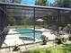 Screened-in pool area with a kidney-shaped pool, patio furniture, and mature landscaping for ultimate relaxation at 29205 Old E Ml, Tavares, FL 32778