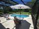 This relaxing screened-in pool area includes patio seating and a clear blue pool at 29205 Old E Ml, Tavares, FL 32778