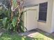 Exterior shot of a storage shed on the side of the home next to dense tropical foliage and a window at 29205 Old E Ml, Tavares, FL 32778