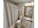 Well-lit bathroom with a shower, stylish vanity, granite counters, and neutral color palette at 295 Whirlaway Drive, Davenport, FL 33837